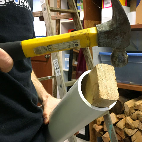 Hammering wood into the end of a PVC pipe