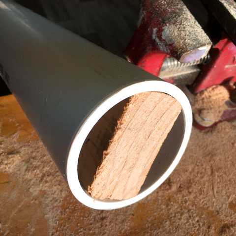 A PVC pipe shimmed with wood